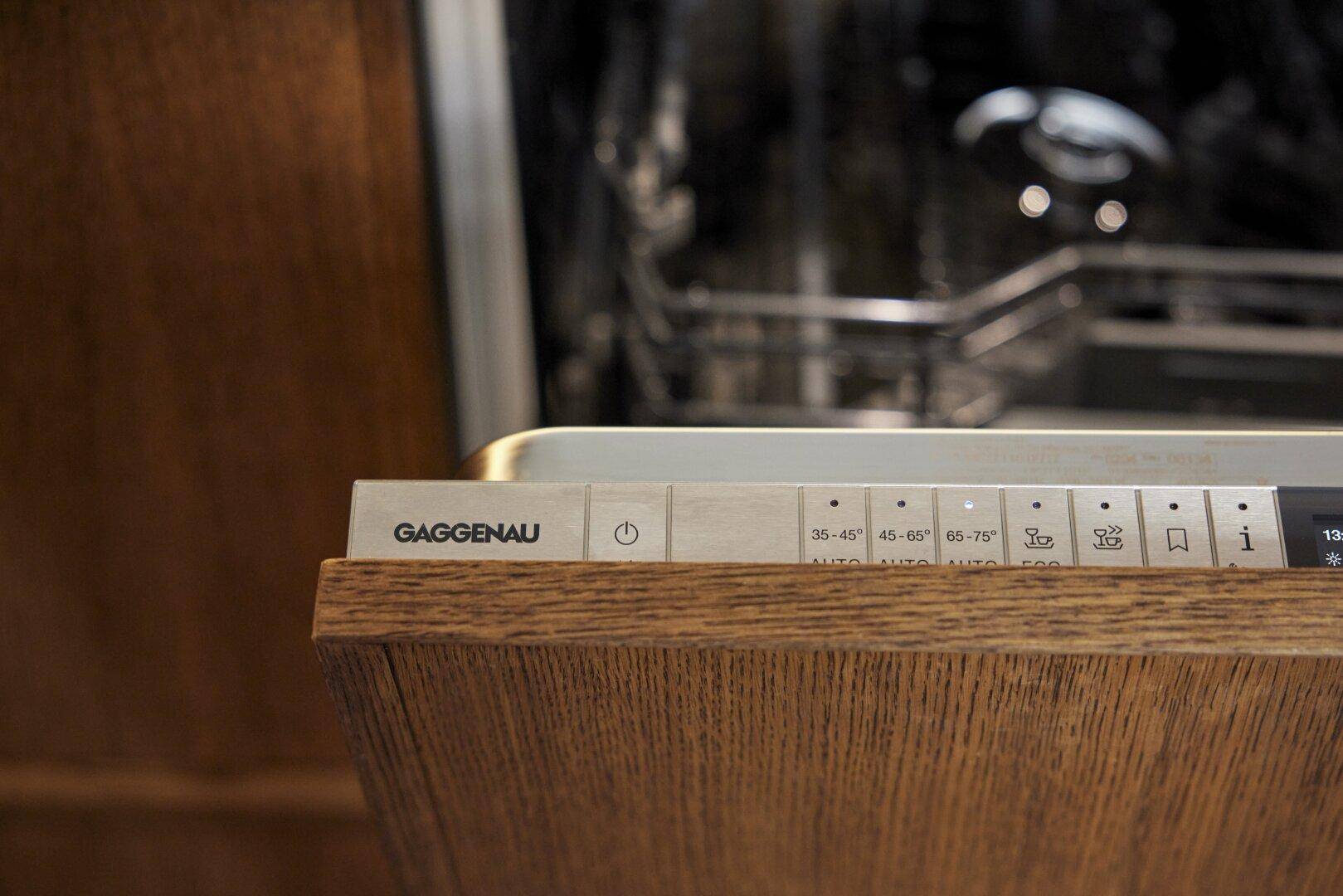 Nahaufnahme einer integrierten Gaggenau Spülmaschine in einer Holzküche.