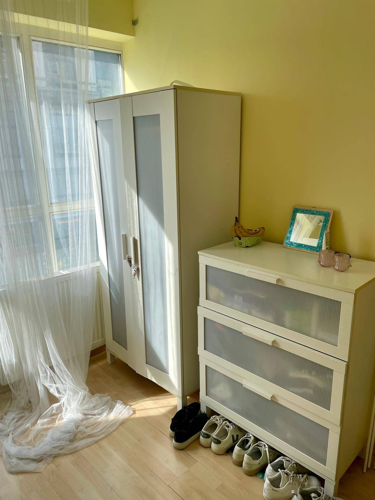 Schlafzimmerbereich mit Kleiderschrank, Kommode und hellem Laminatboden.