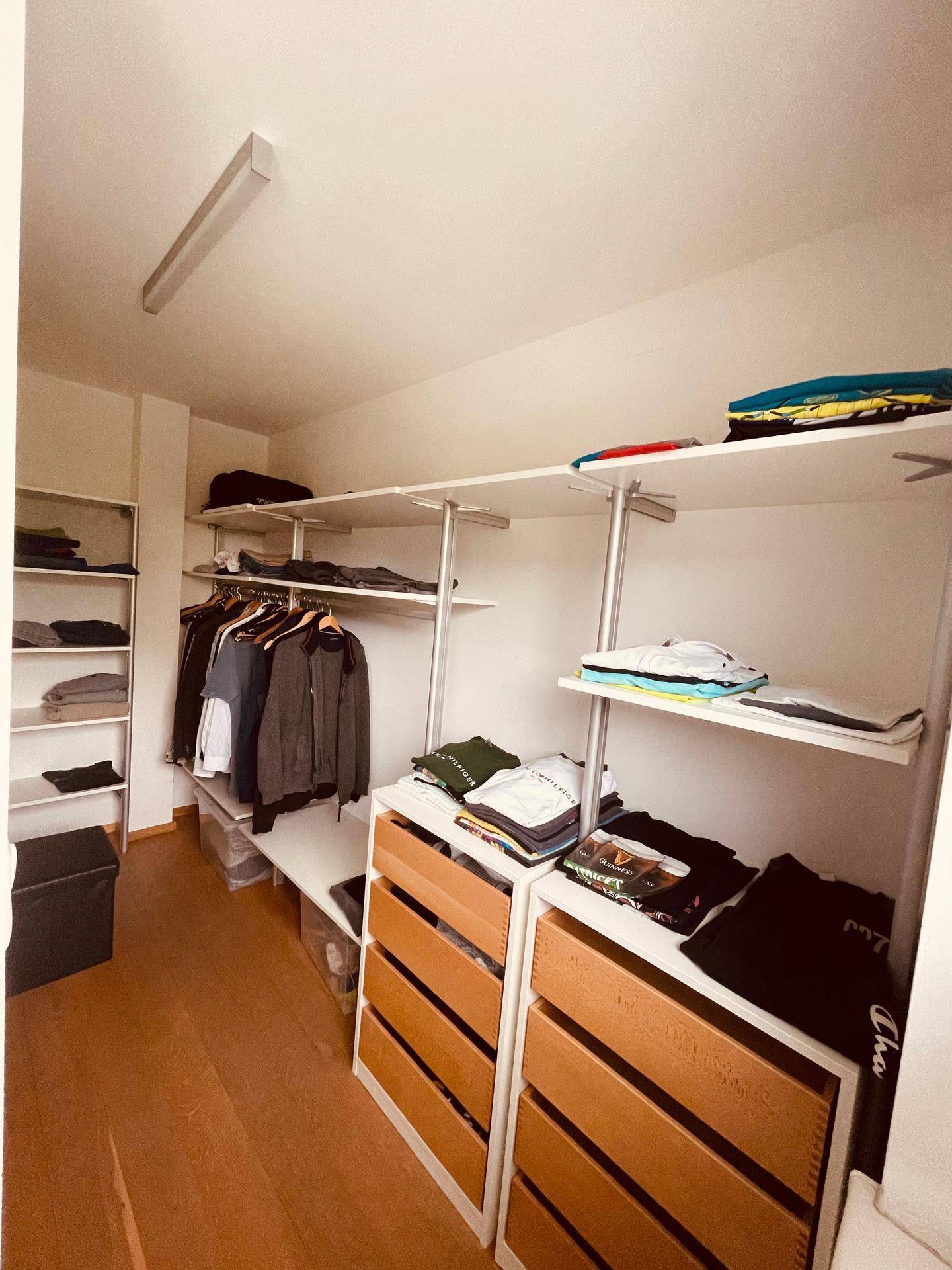Praktischer begehbarer Kleiderschrank mit Regalen und Schubladen für ausreichend Stauraum.