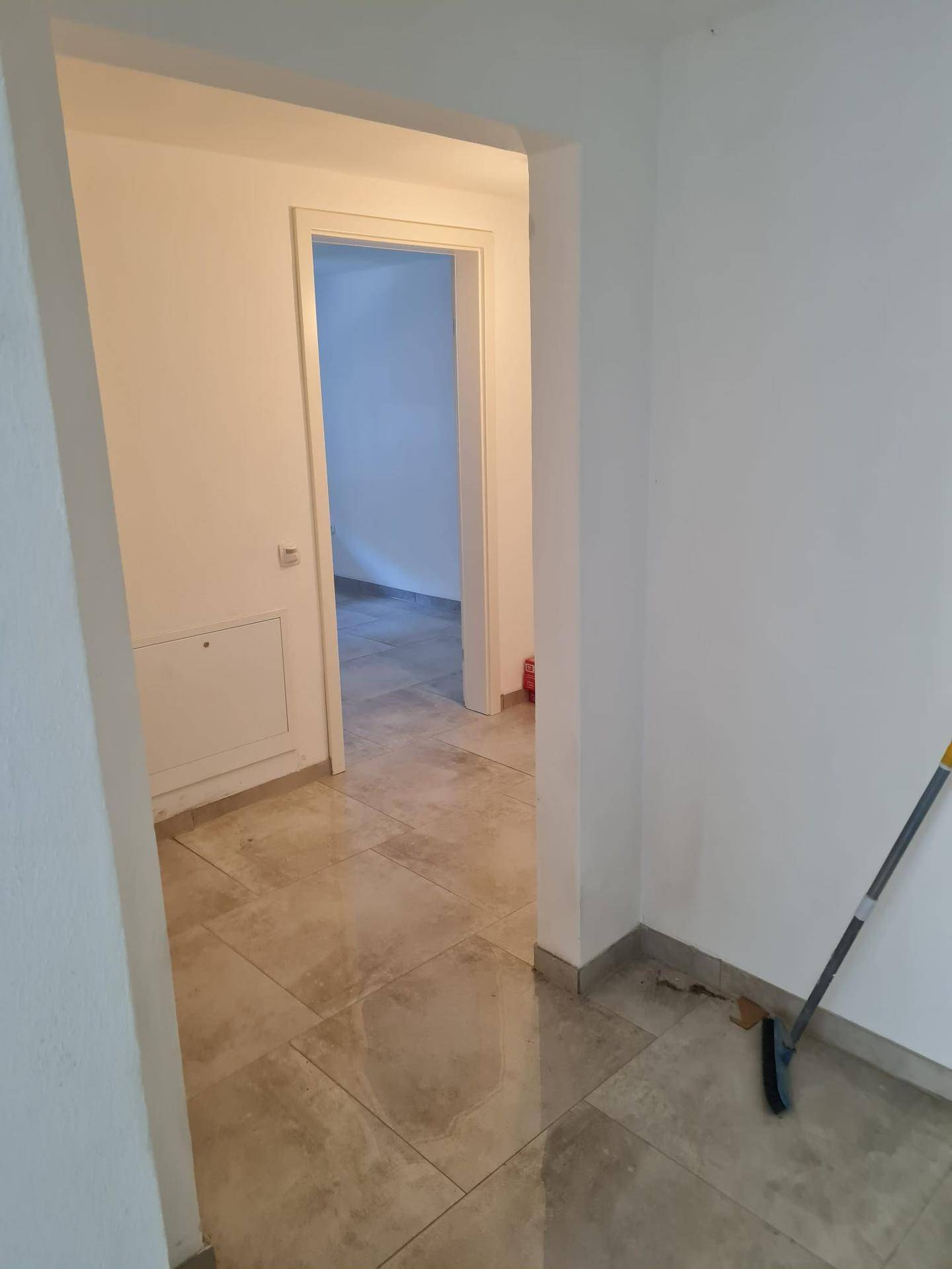 Geräumiger Flur mit Fliesenboden, der den Zugang zu verschiedenen Zimmern der Wohnung ermöglicht.