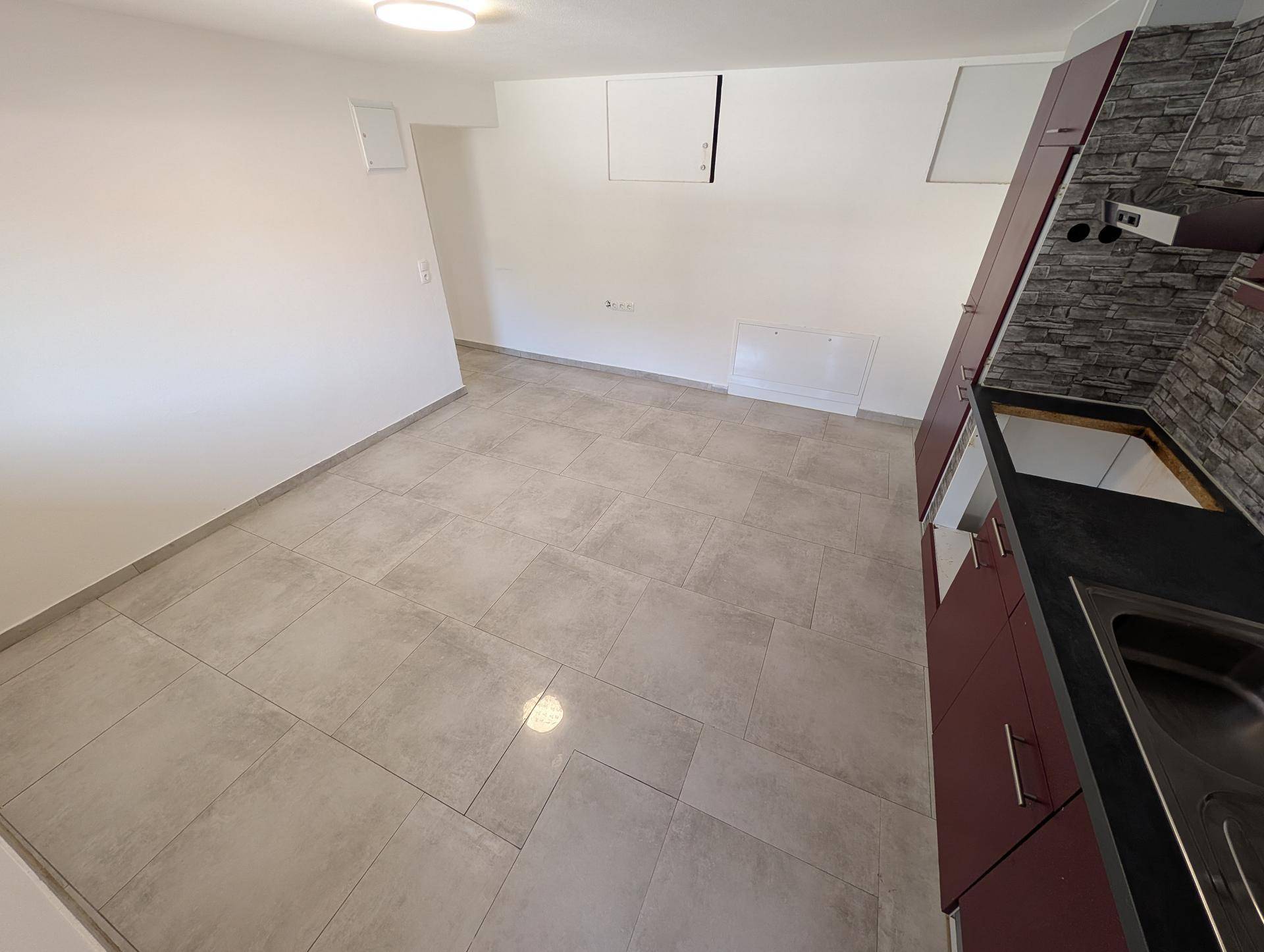 Geräumiger Küchenbereich mit Einbauküche und viel Platz, ideal für einen Essbereich.