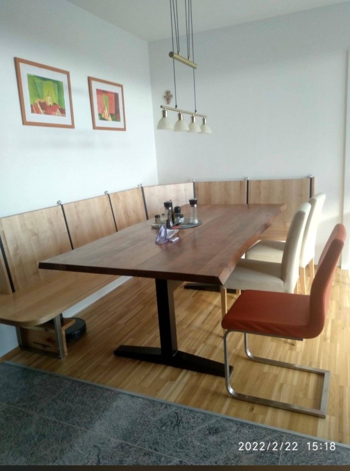 Gemütlicher Essbereich mit Holztisch, Eckbank und modernen Stühlen auf Parkettboden.