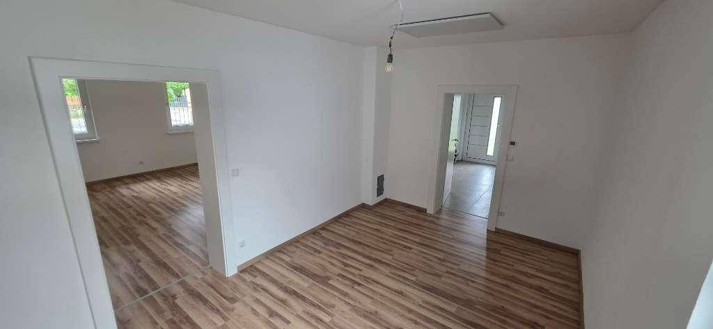 Geräumiges, unmöbliertes Zimmer mit Holzboden und hellen Wänden, bereit zur individuellen Gestaltung.