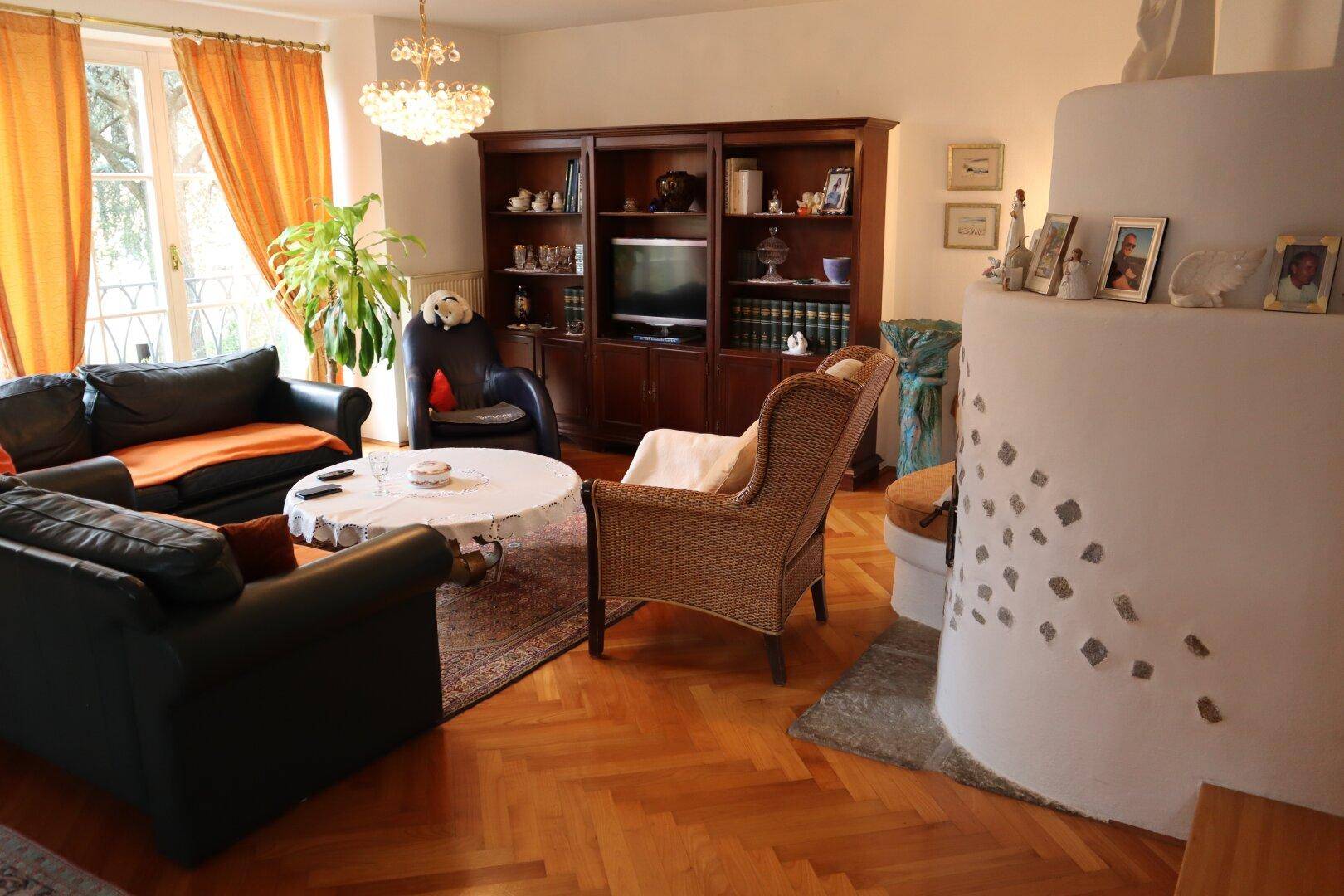 Gemütliches Wohnzimmer mit Fischgrätparkett und Kaminofen.
