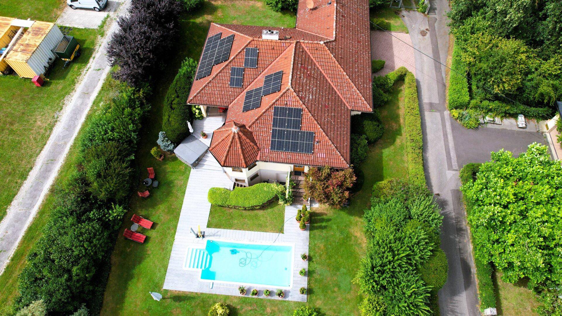Gesamtansicht des Anwesens von oben mit großem Garten, Pool und Solaranlagen auf dem Dach.