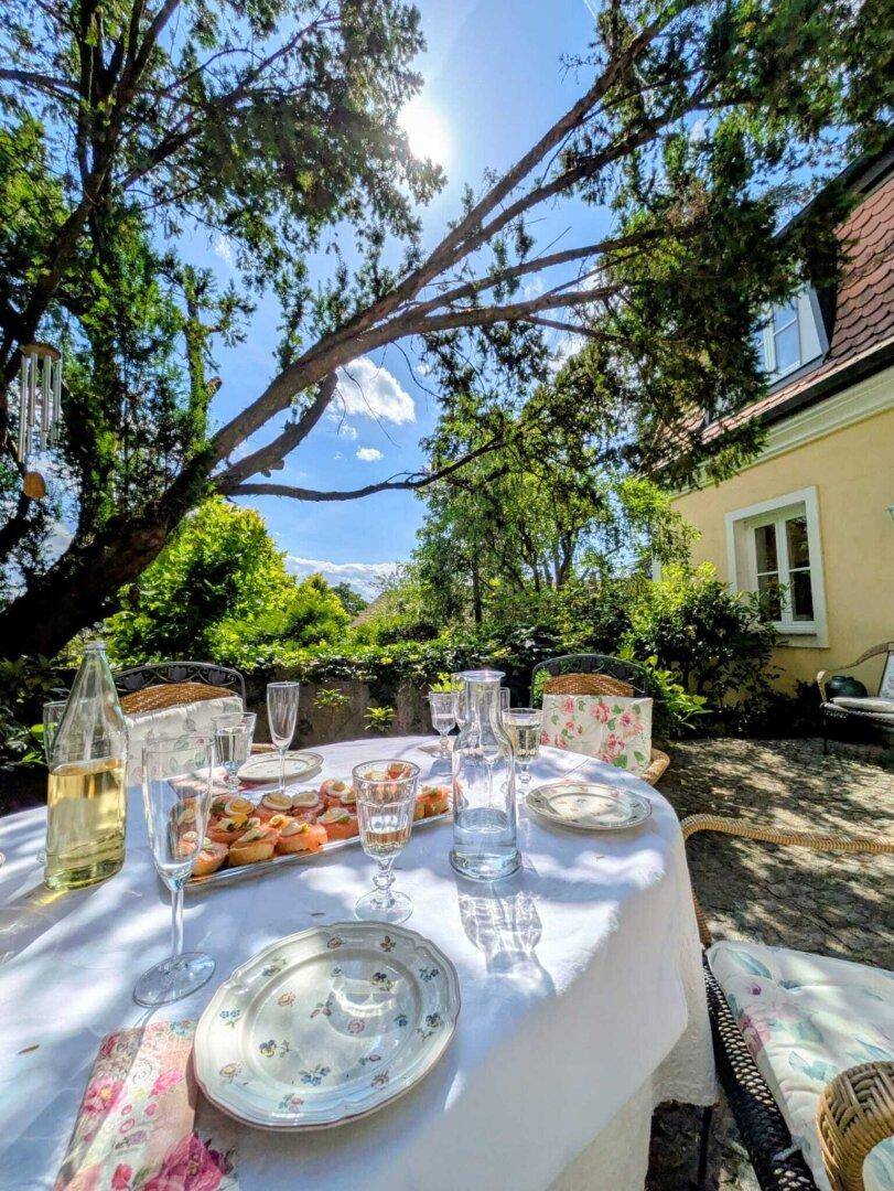 Einladender Esstisch auf der Terrasse, umgeben von üppigem Grün und mit Blick auf die Ferne.