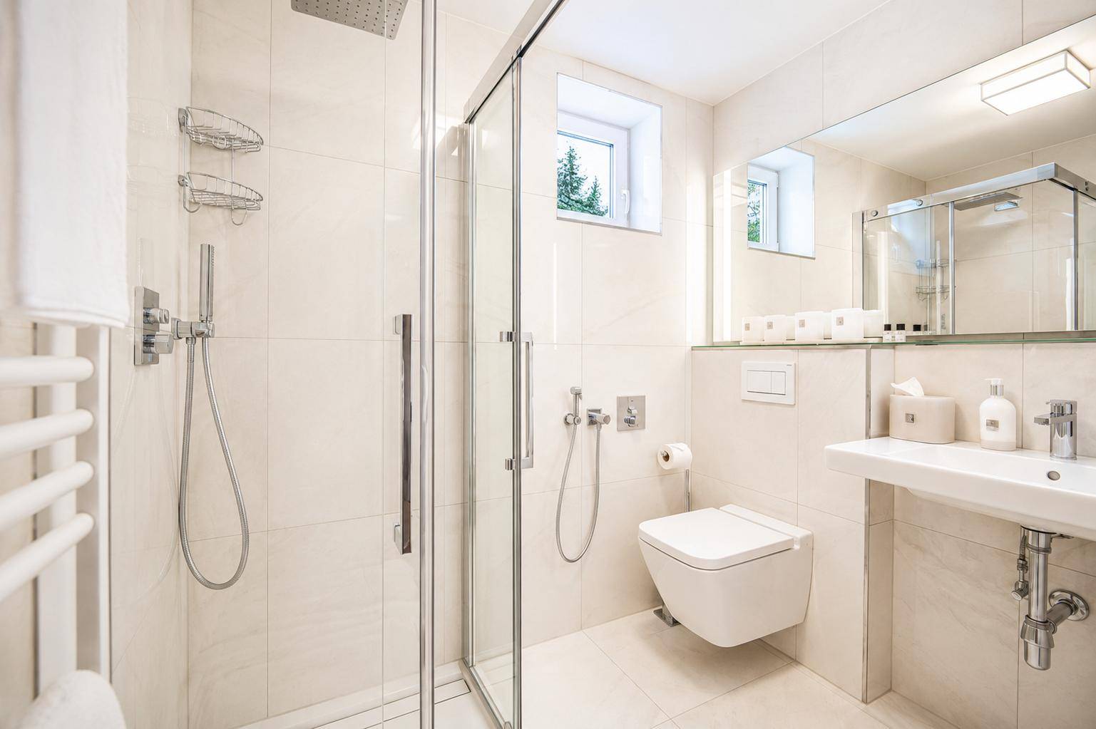 Modernes Badezimmer mit begehbarer Dusche, wandhängendem WC und Fenster.