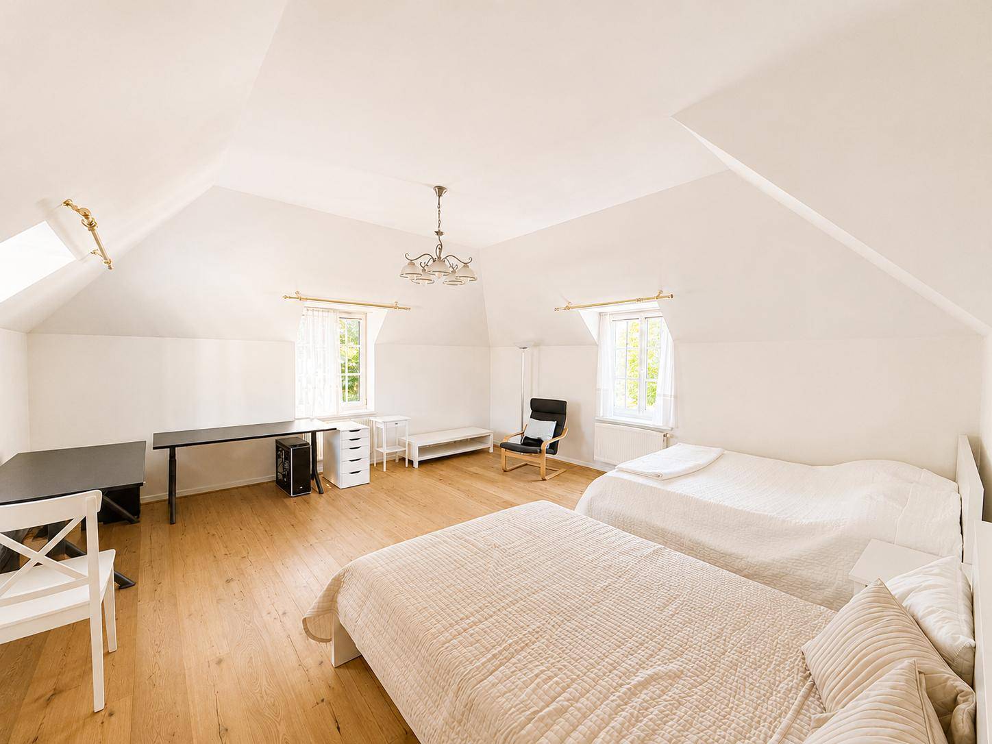 Großes Schlafzimmer im Dachgeschoss mit zwei Betten, Holzboden und viel Platz.