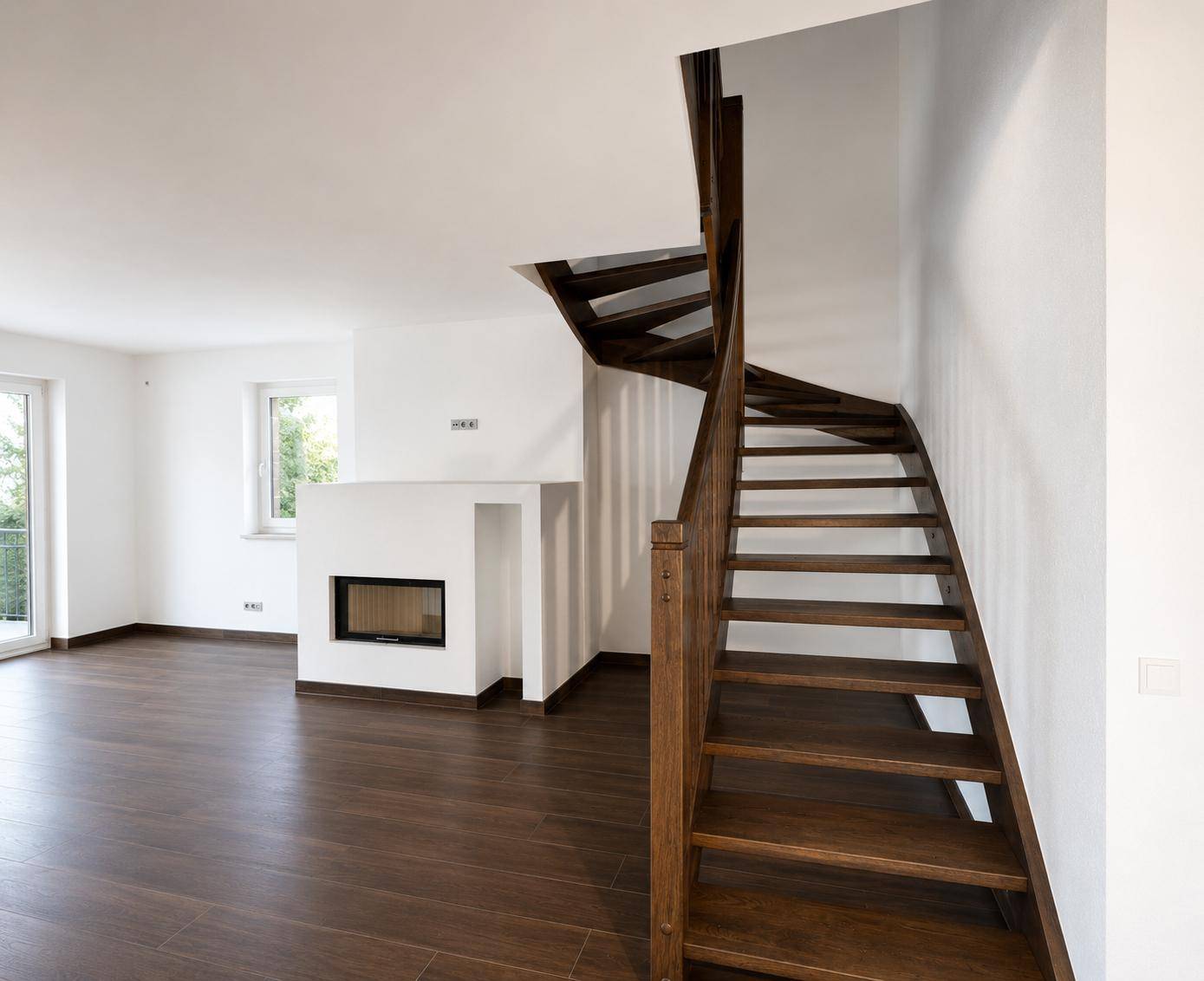 Elegante Holztreppe in einem hellen Raum mit modernem Kamin und dunklem Holzboden.
