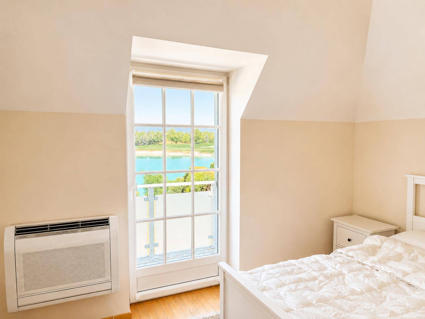 Schlafzimmer mit großem Fenster, das einen schönen Blick auf den See bietet.