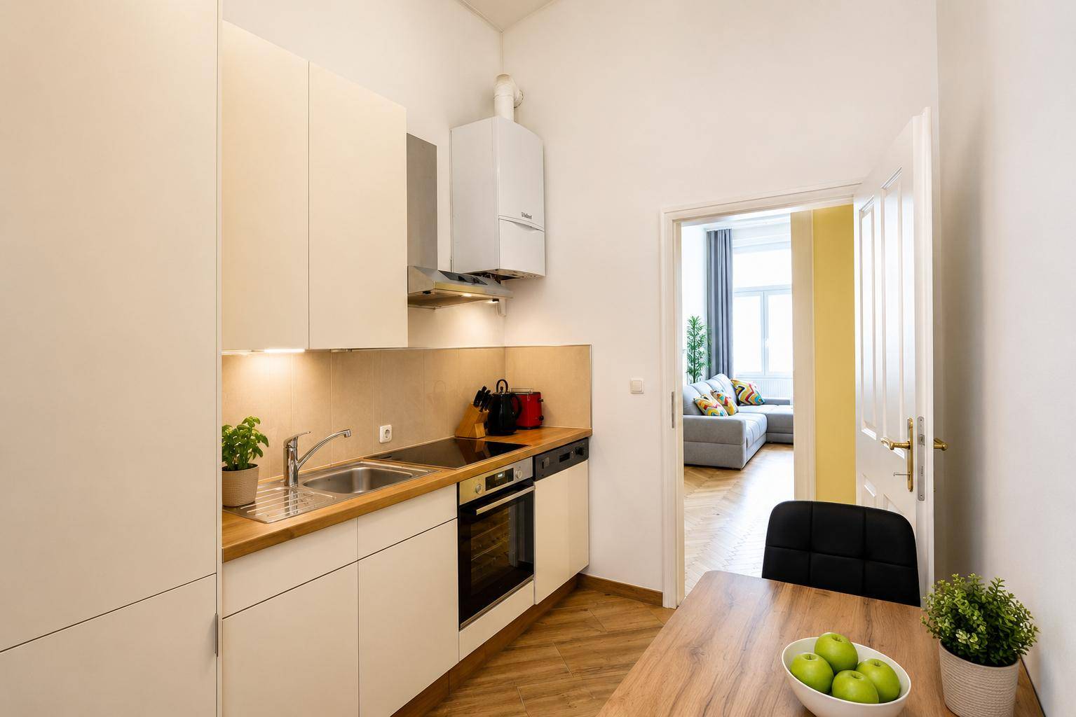 Moderne Küche mit weißen Schränken, Holzarbeitsplatte und integrierten Geräten.
