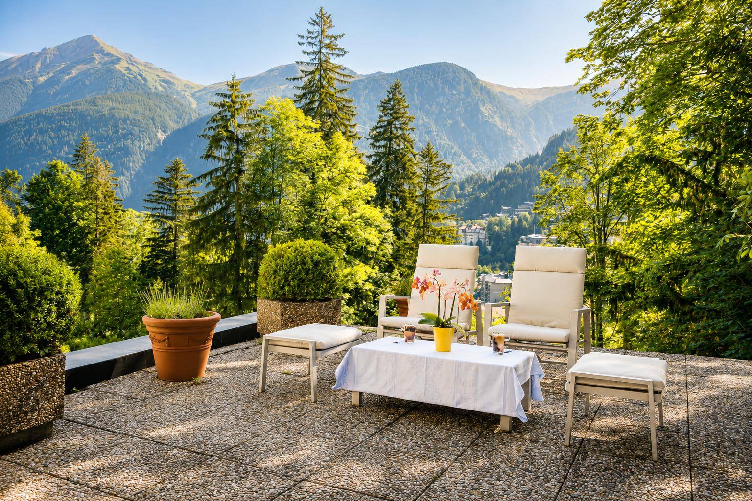 Große Sonnenterrasse mit bequemen Gartenmöbeln und weitem Blick auf die Berglandschaft.
