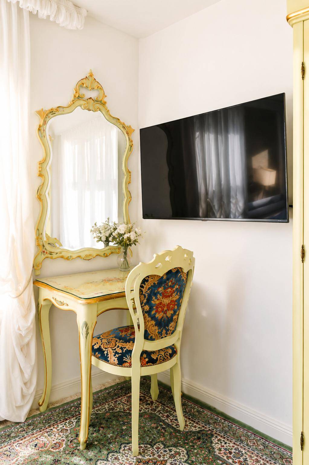 Elegante Schminkecke mit verziertem Spiegel und Stuhl in einem hellen Schlafzimmer.