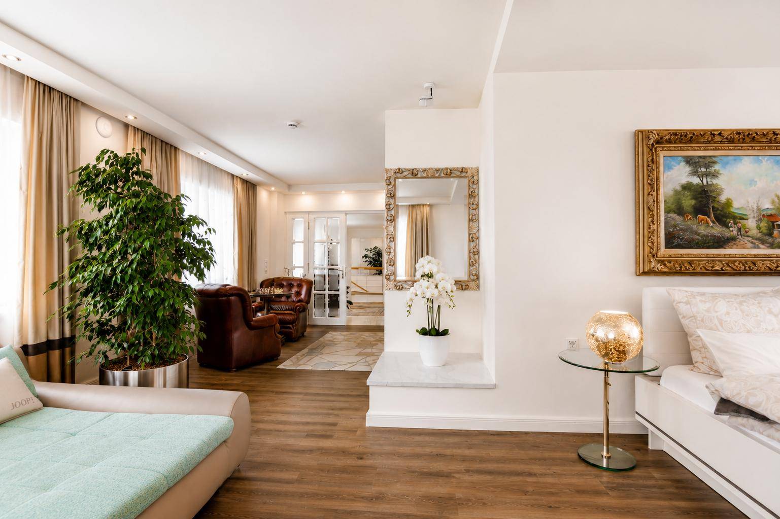 Heller und geräumiger Wohnbereich mit bequemer Couch, großem Spiegel und Holzboden.