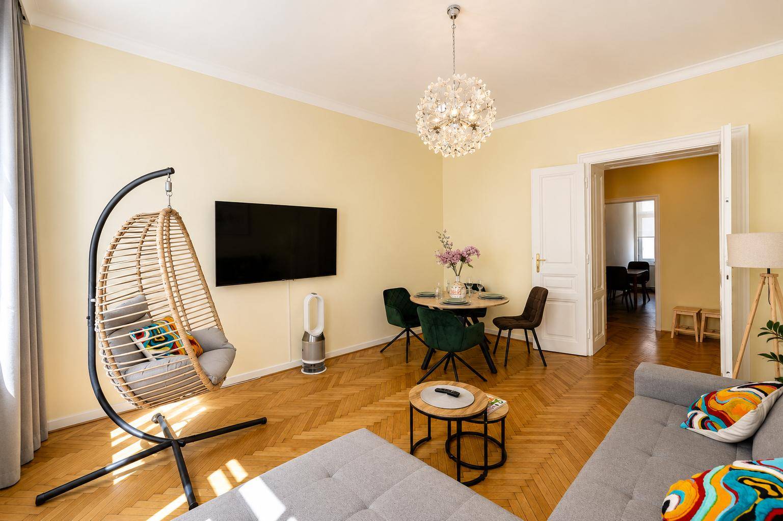 Geräumiger Wohn- und Essbereich mit bequemer Couch, Hängesessel und Parkettboden.