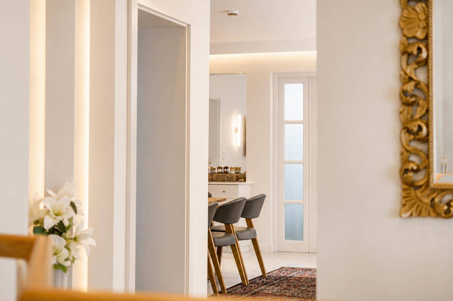 Heller Flur mit modernem Design, Spiegel und Blick in angrenzende Räume.