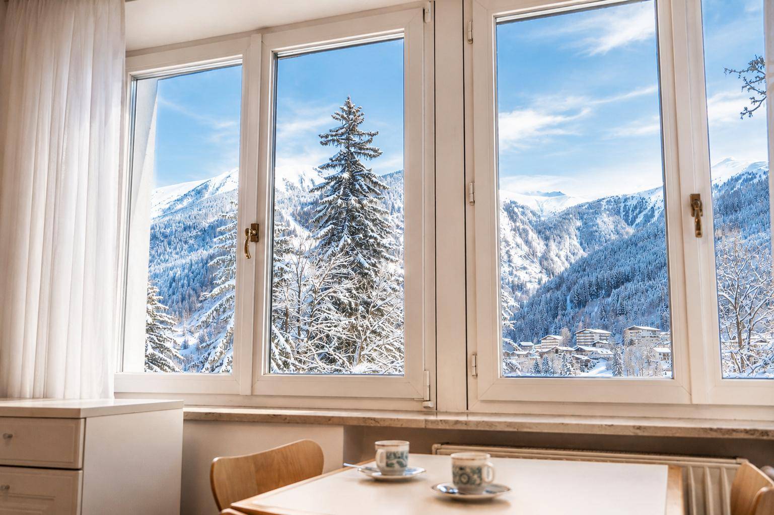 Heller Essbereich mit Tisch und Stühlen, bietet einen atemberaubenden Blick auf die verschneiten Berge.