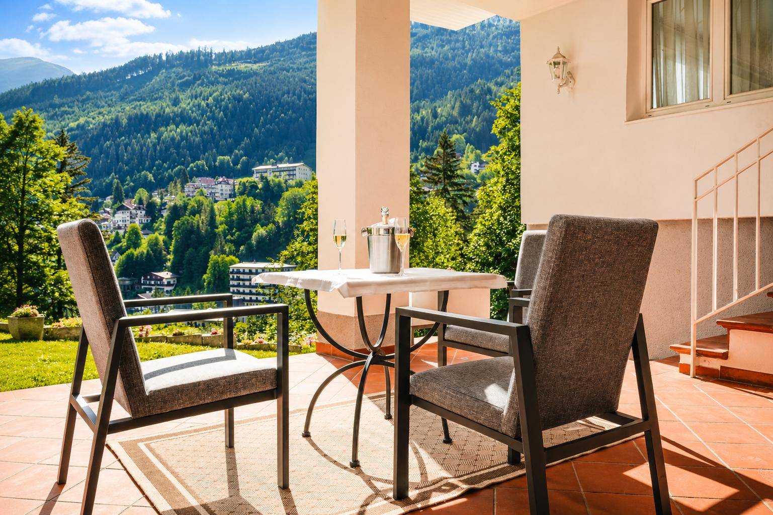 Sonniger Terrassenbereich mit Sitzgelegenheiten und einem atemberaubenden Blick auf die Berge.
