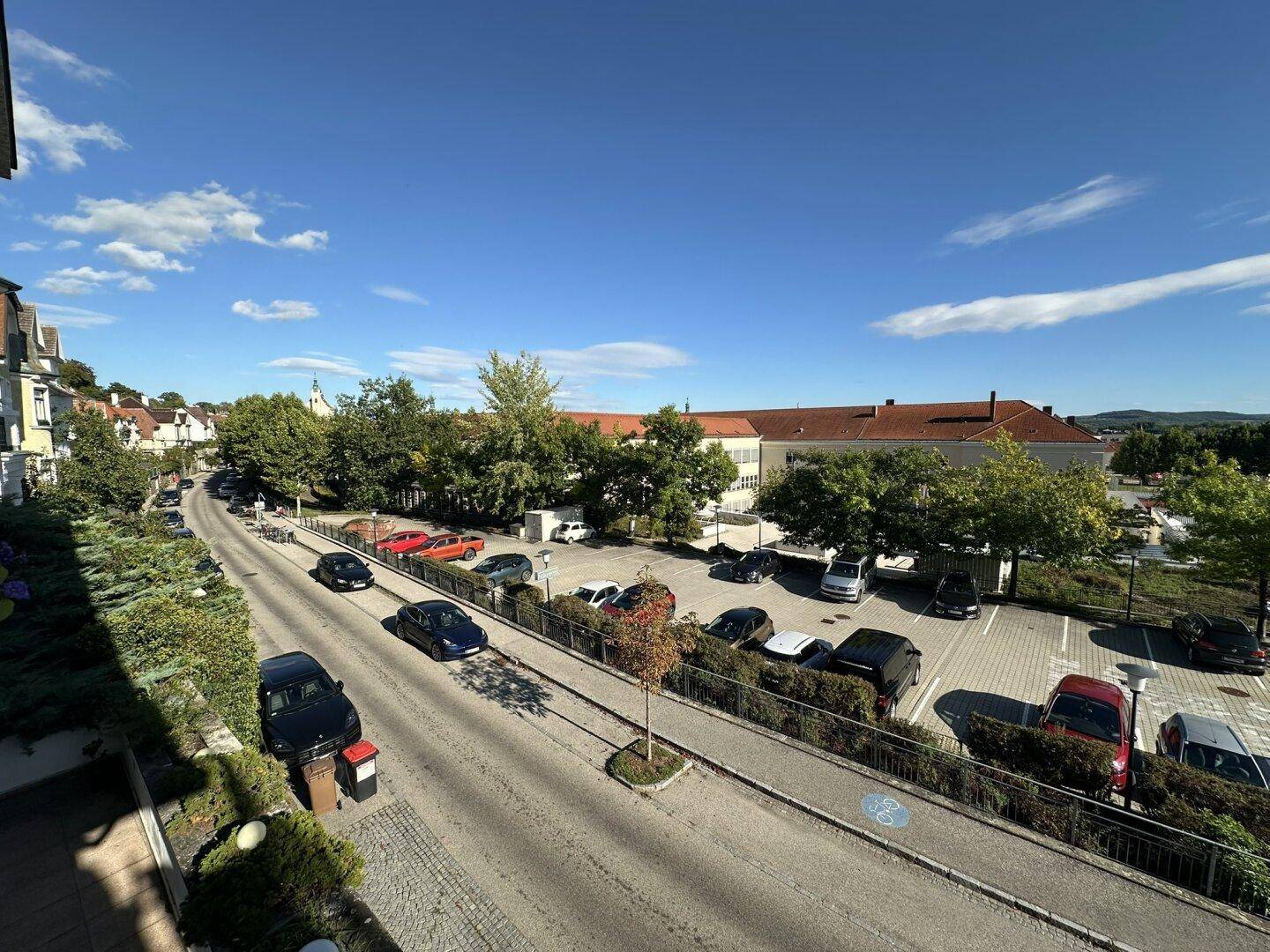 Weitläufiger Blick über die Straße, Parkplätze und die umliegende Stadtlandschaft.