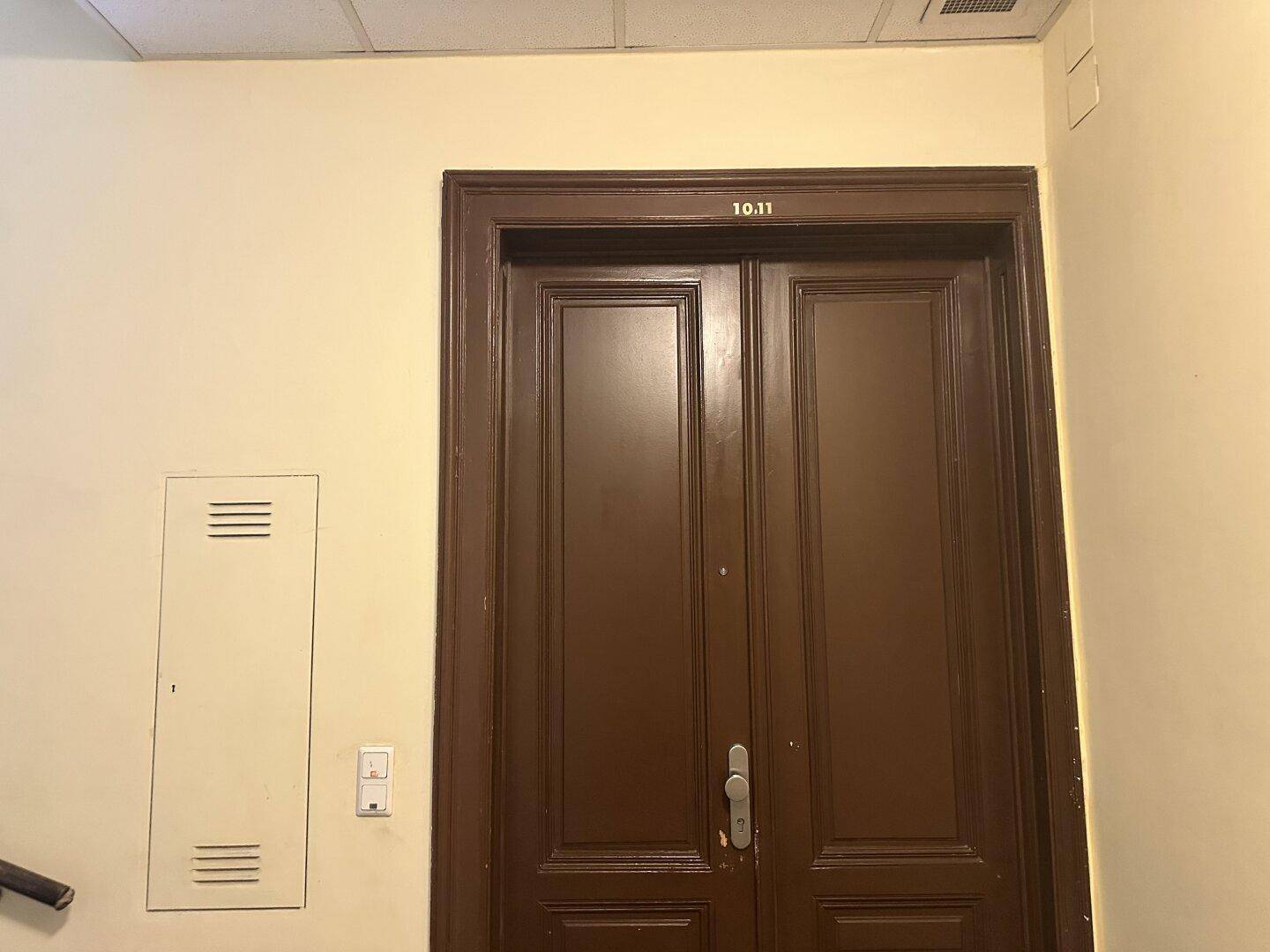 Braune Holztür zu den Wohnungen 10 und 11 in einem Altbauflur.