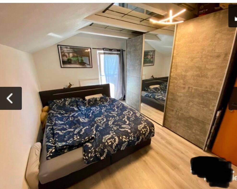 Schlafzimmer im Dachgeschoss mit Doppelbett und großem Spiegelschrank.