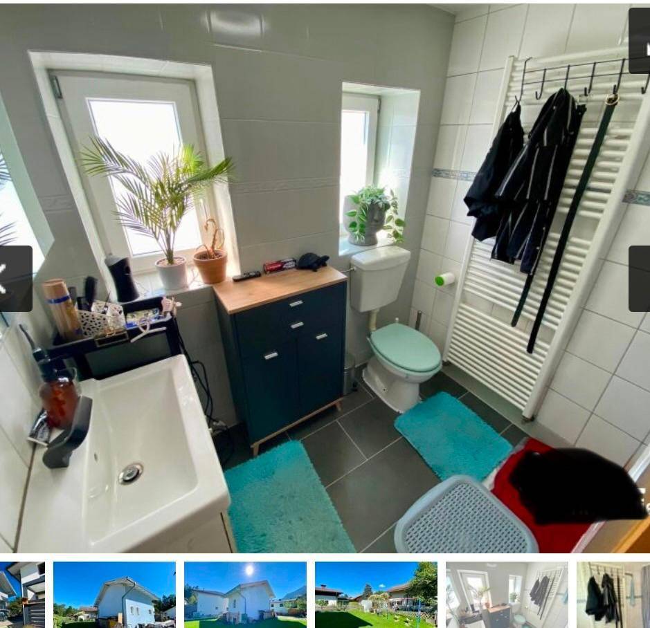 Helles Badezimmer mit Fenster, Einzelwaschbecken und beheiztem Handtuchhalter.