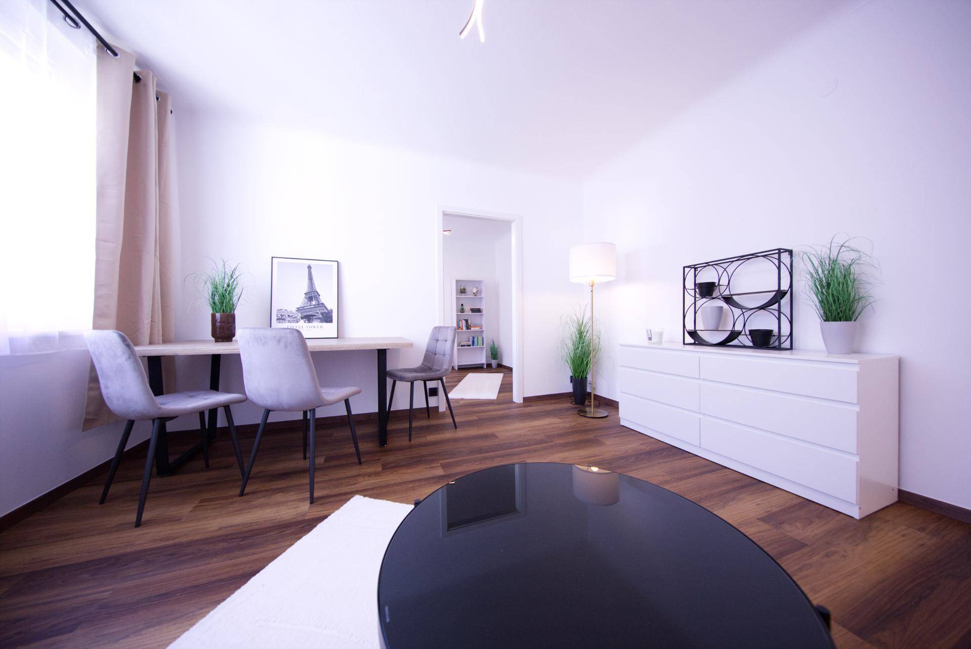 Geräumiges Wohnzimmer mit Essbereich, Holzboden und moderner Einrichtung, lichtdurchflutet.
