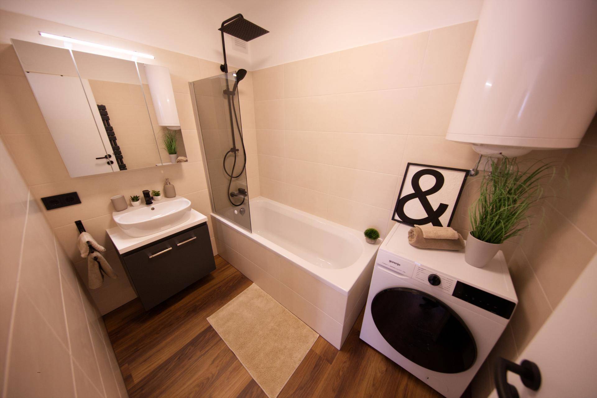 Modernes Badezimmer mit Badewanne, Dusche und Waschmaschine, funktional und stilvoll gestaltet.