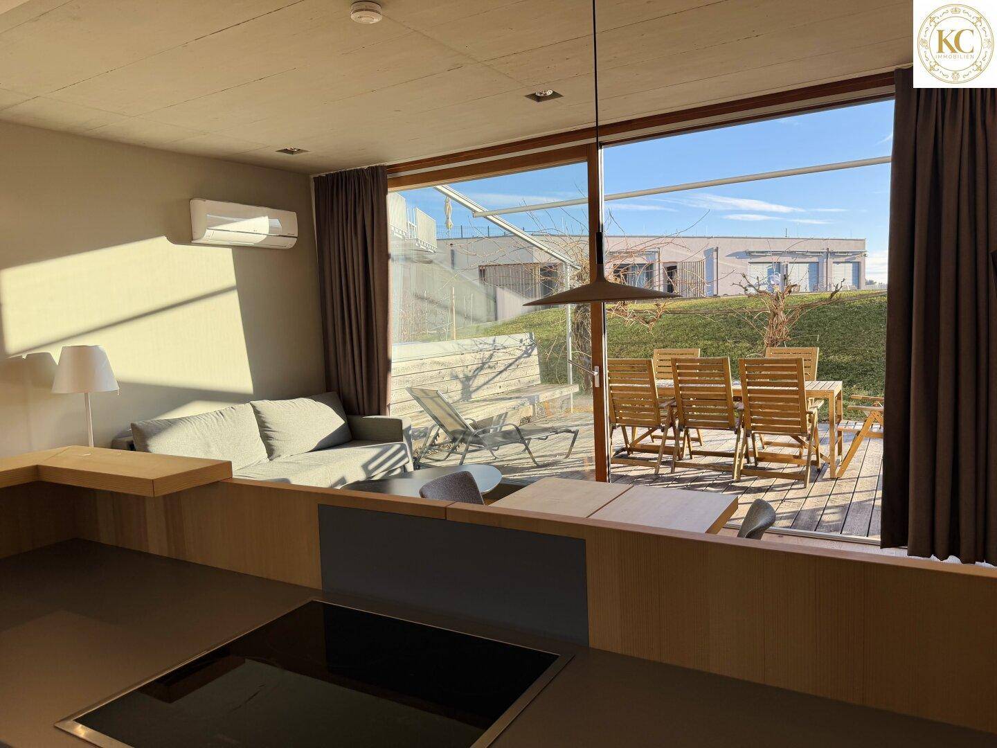 Offener Wohnbereich mit integrierter Küche und direktem Zugang zur sonnigen Außenterrasse.