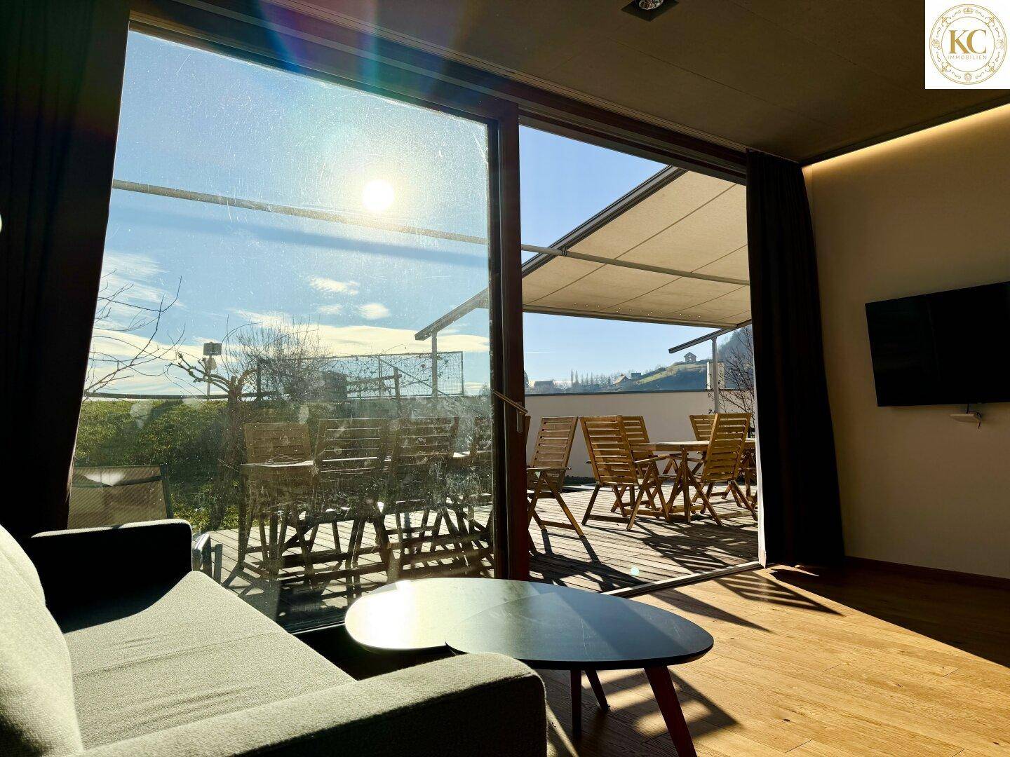 Lichtdurchfluteter Wohnbereich mit Zugang zur Sonnenterrasse und weitem Blick in die Natur.