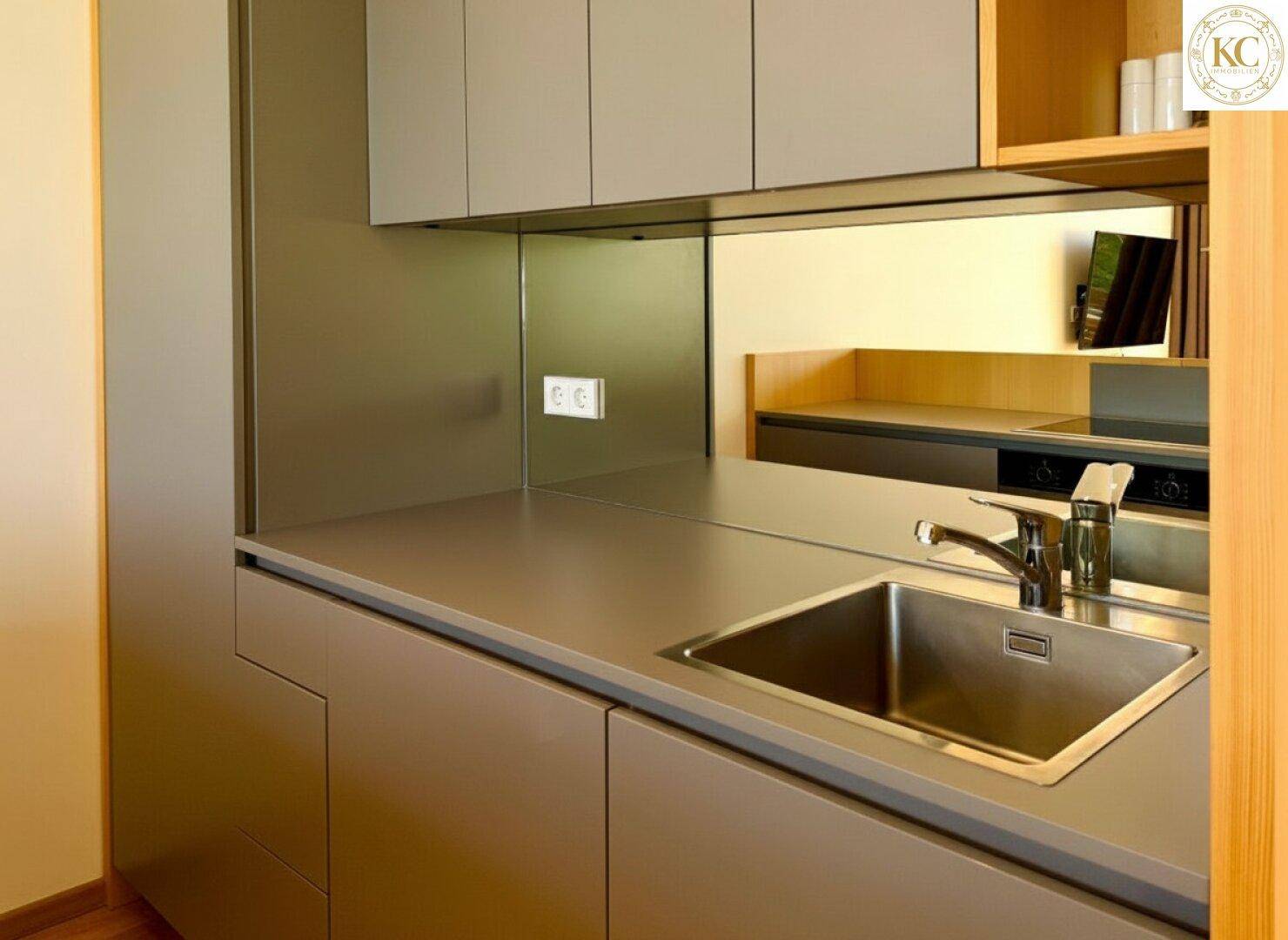 Moderne Küchenzeile mit grauen Fronten, integrierter Spüle und hochwertiger Arbeitsplatte.