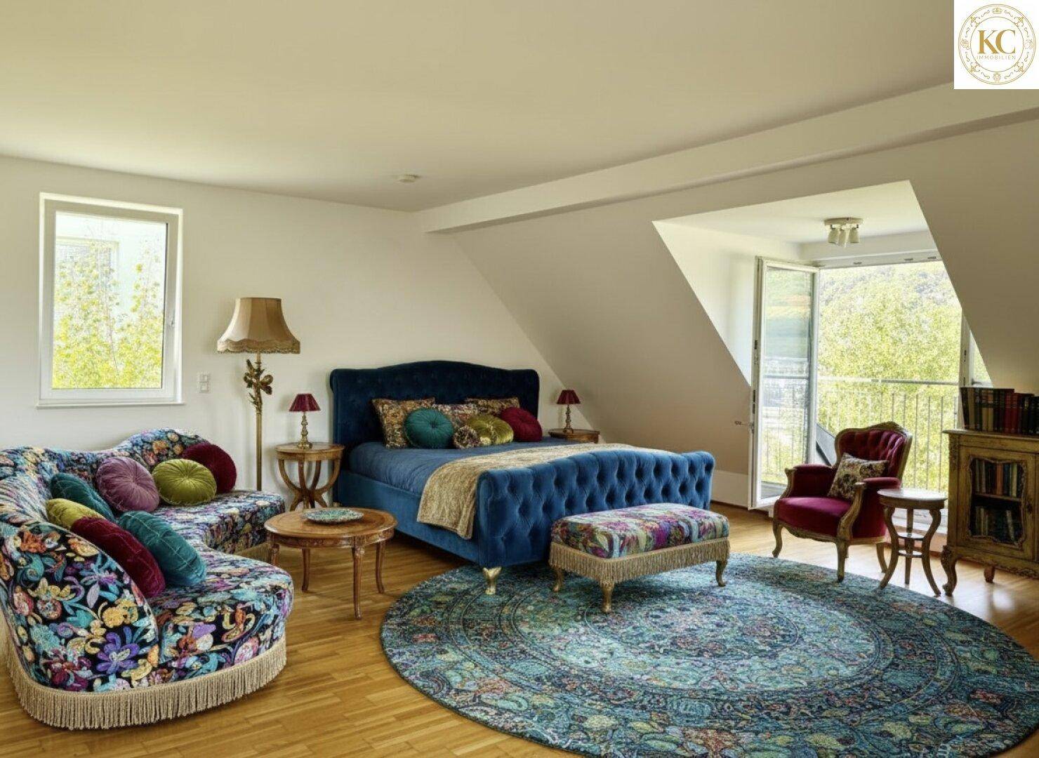 Gemütliches Schlafzimmer im Dachgeschoss mit farbenfrohen Möbeln, Holzboden und Zugang zum Balkon.