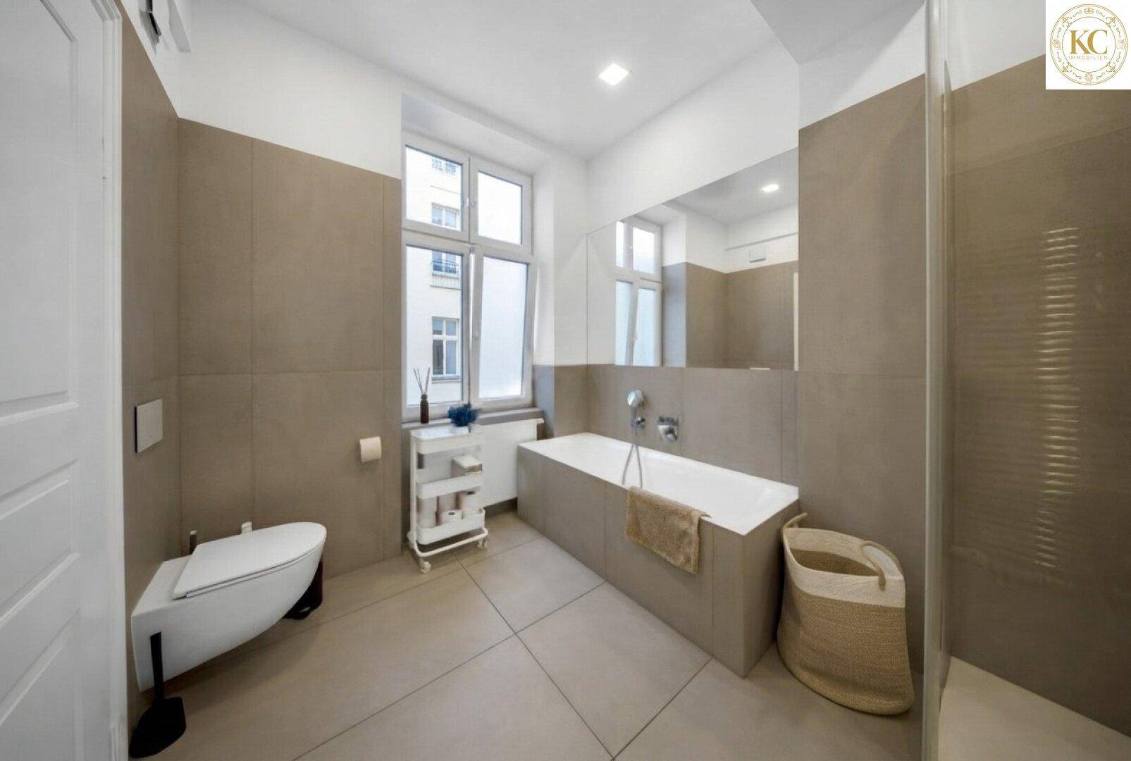 Elegantes Badezimmer mit Badewanne, Duschbereich, WC und einem Fenster für natürliche Belüftung.