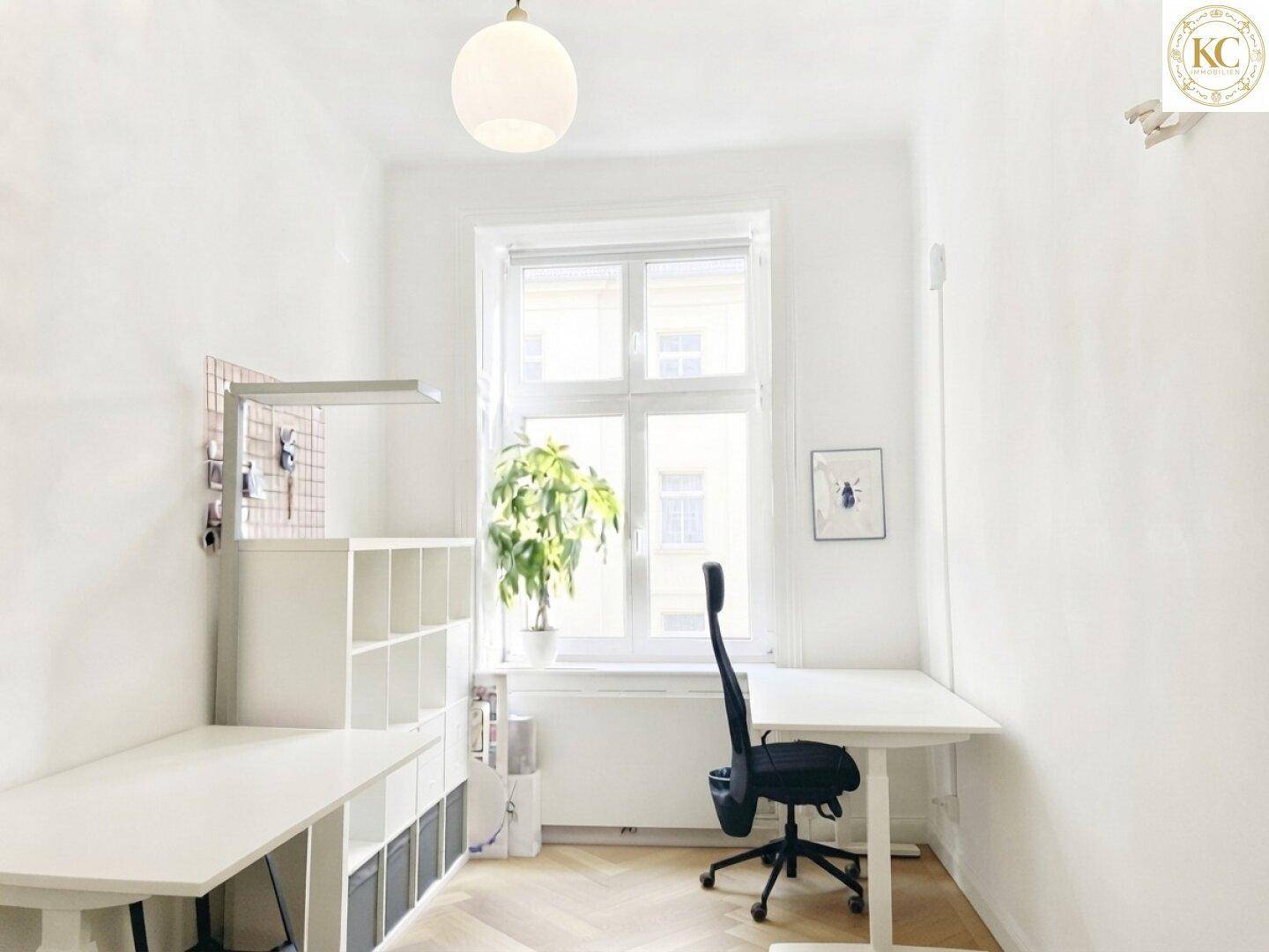 Helles Einzelbüro mit Schreibtisch, Regalen und einem großen Fenster für viel Tageslicht.