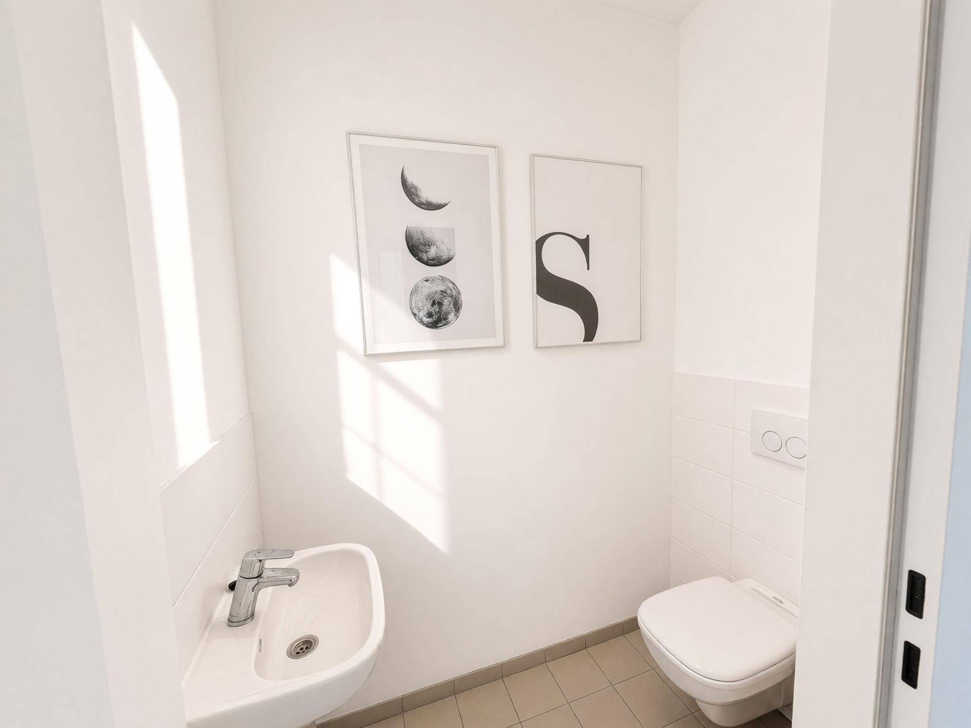 Kleines Gäste-WC mit modernem Waschbecken und Toilette, hell und funktional.
