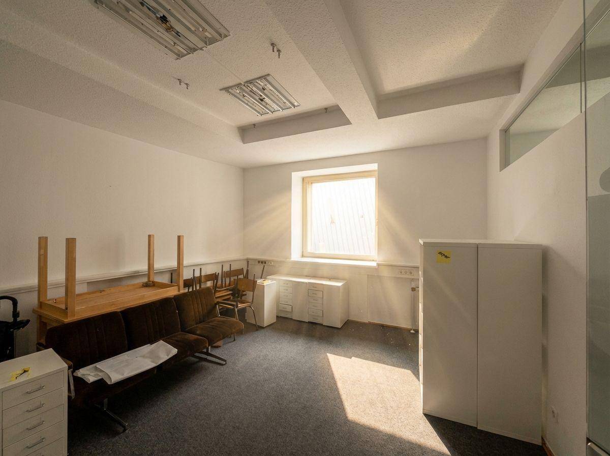 Büroraum mit einigen Möbeln und Schränken, die auf eine bevorstehende Nutzung oder Umgestaltung hindeuten.