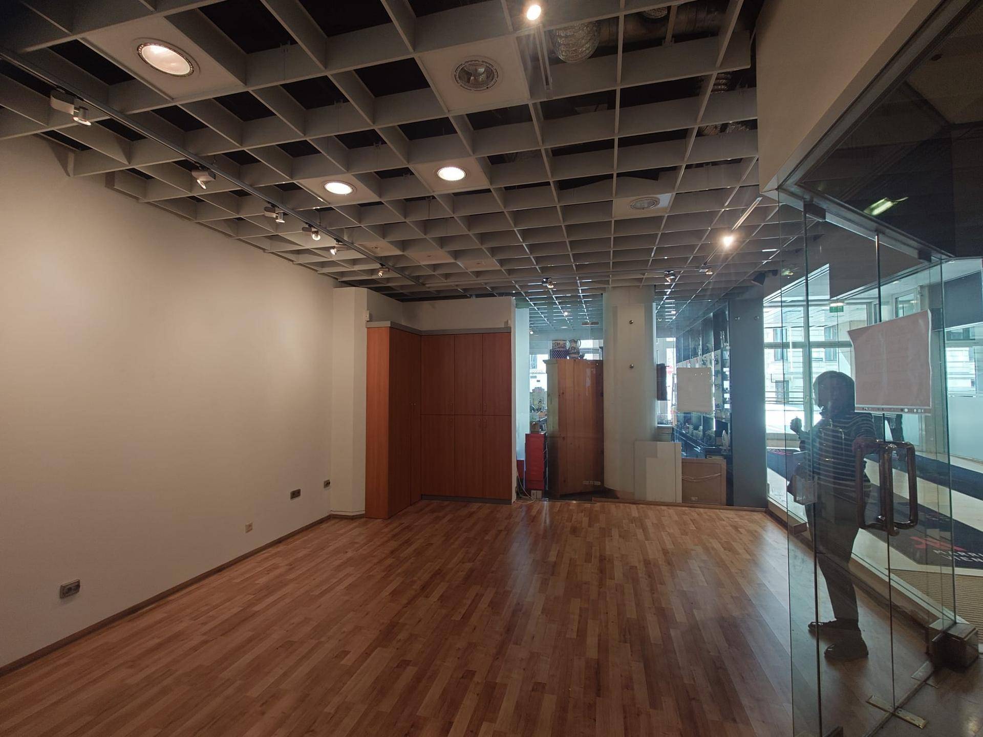 Leerer Raum mit Holzboden, weißen Wänden und Einbauschränken, ideal für Büro- oder Ladenflächen.