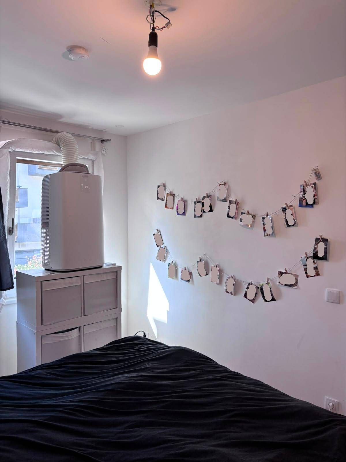 Schlafzimmer mit Klimaanlage, Doppelbett und Fenster.