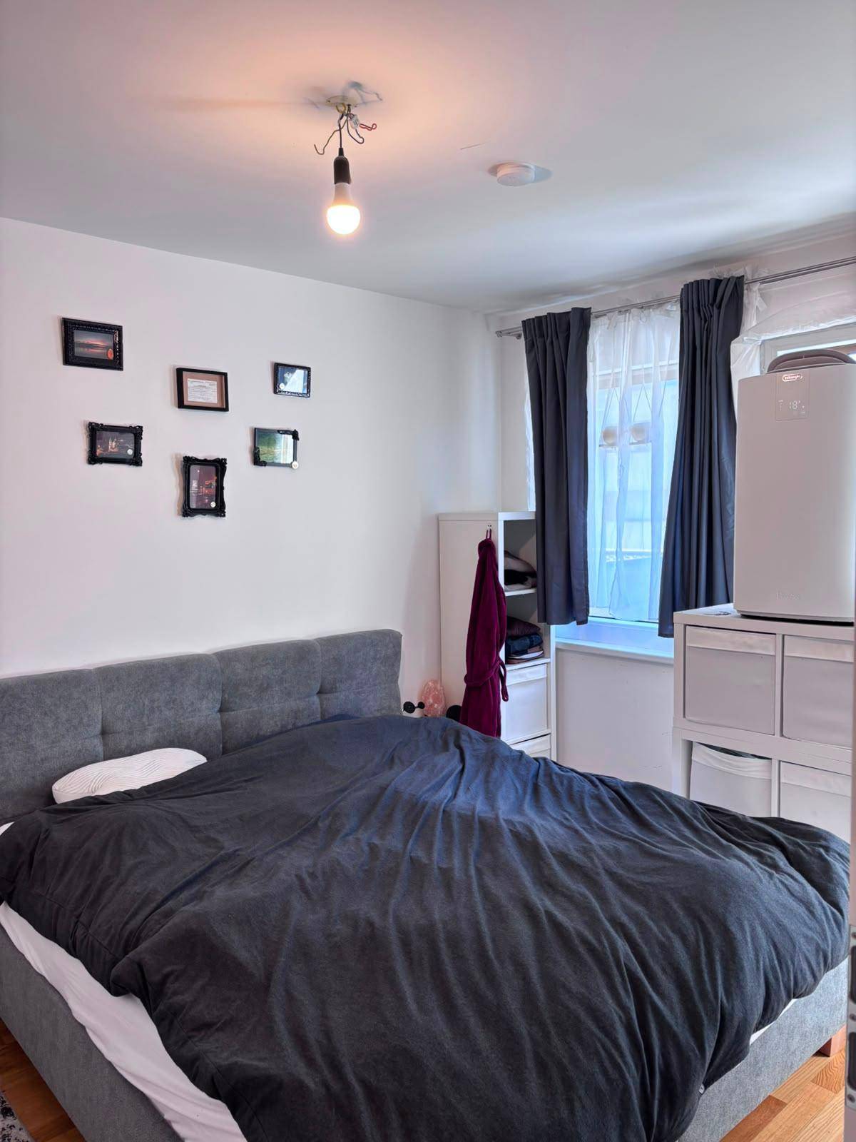 Schlafzimmer mit Doppelbett, Kleiderschrank und Holzboden.