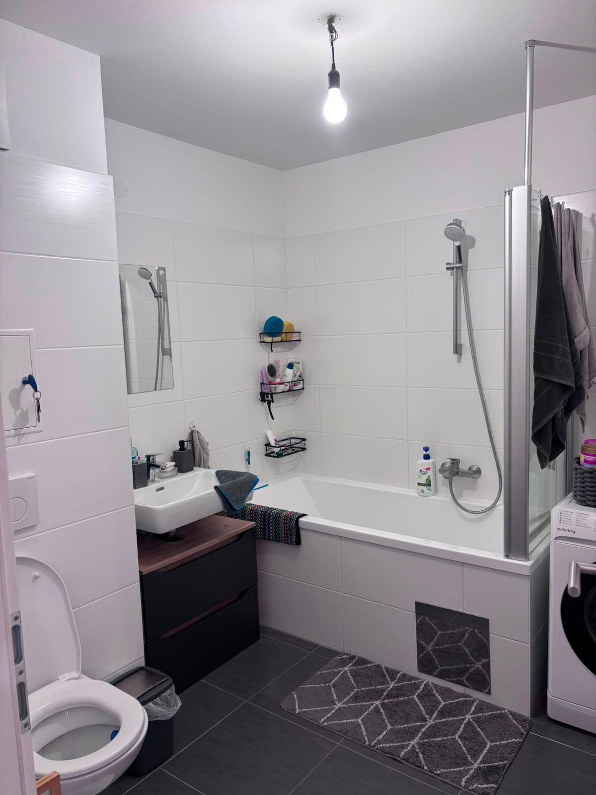 Modernes Badezimmer mit Badewanne, Dusche und Waschbecken.