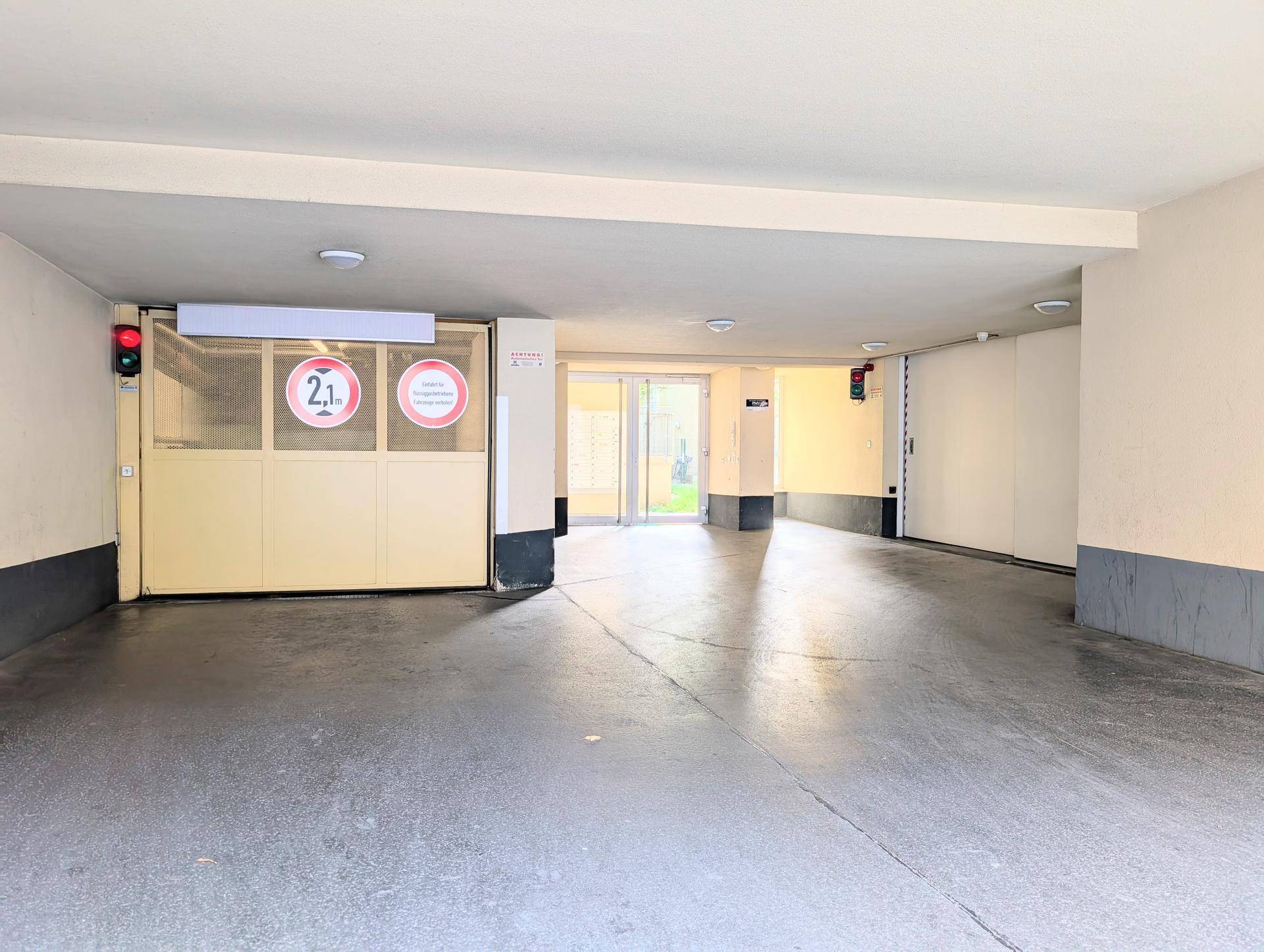 Einfahrt zur Tiefgarage mit Ampelsystem und Höhenbegrenzungsschildern.