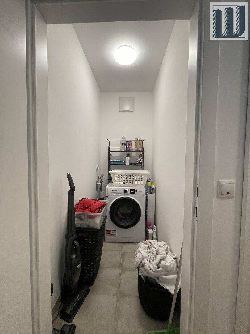 Praktischer Hauswirtschaftsraum mit Waschmaschine und Stauraum, funktional eingerichtet.