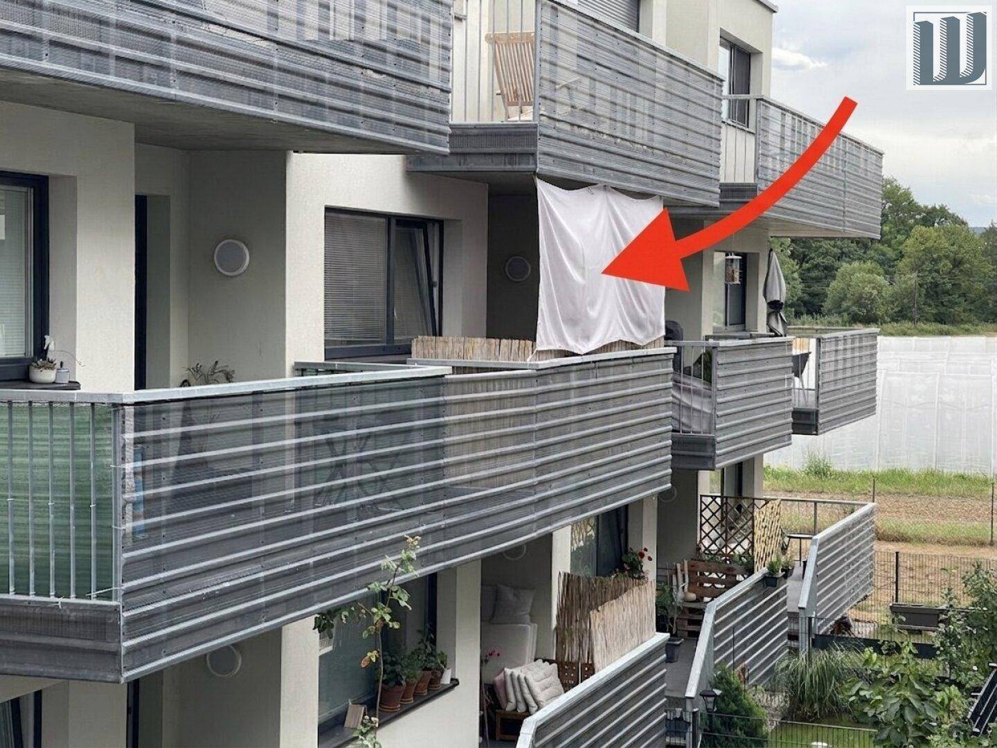 Mehrere Balkone eines modernen Wohngebäudes mit Sichtschutz und Pflanzen.