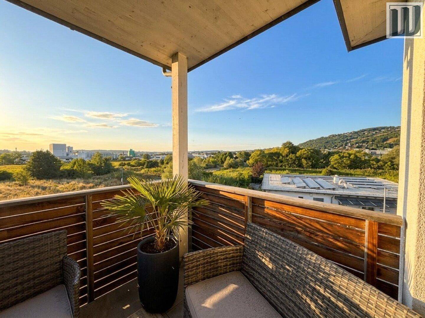 Balkon mit Sitzgelegenheiten und Panoramablick über die Landschaft und die Stadt.