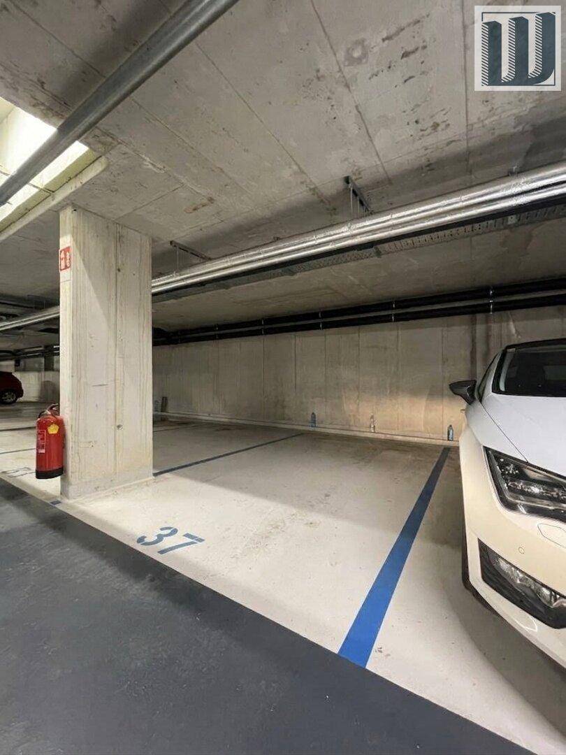 Tiefgaragenstellplatz Nummer 37 mit Betonwänden und Feuerlöscher, sicher und geschützt.