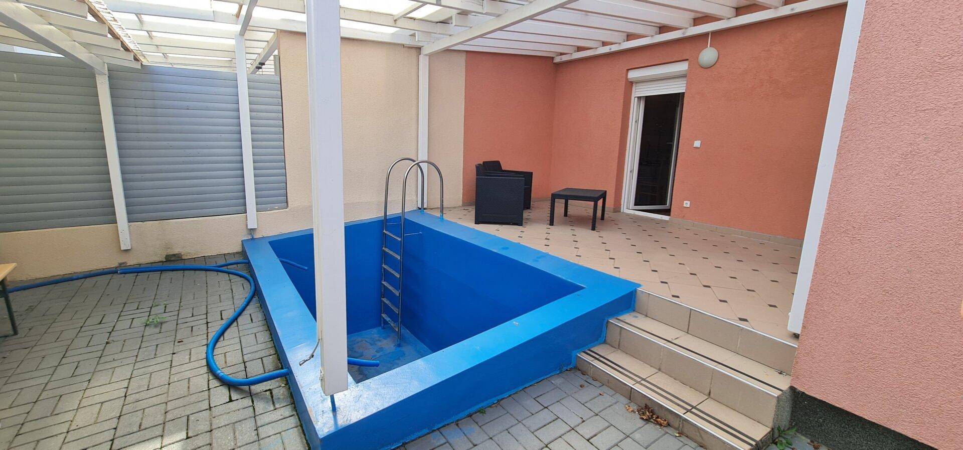 Überdachter Außenbereich mit kleinem Pool, Terrasse und Stufen zum Wohnhaus.