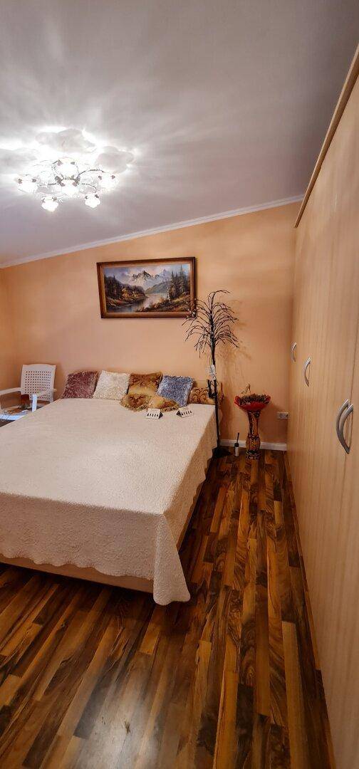 Gemütliches Schlafzimmer mit Holzboden, Doppelbett und warmer Wandfarbe für entspannte Nächte.