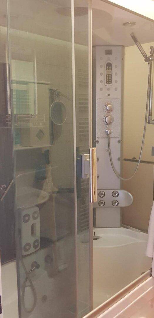 Moderne Duschkabine mit verschiedenen Massagedüsen und Steuerungselementen.
