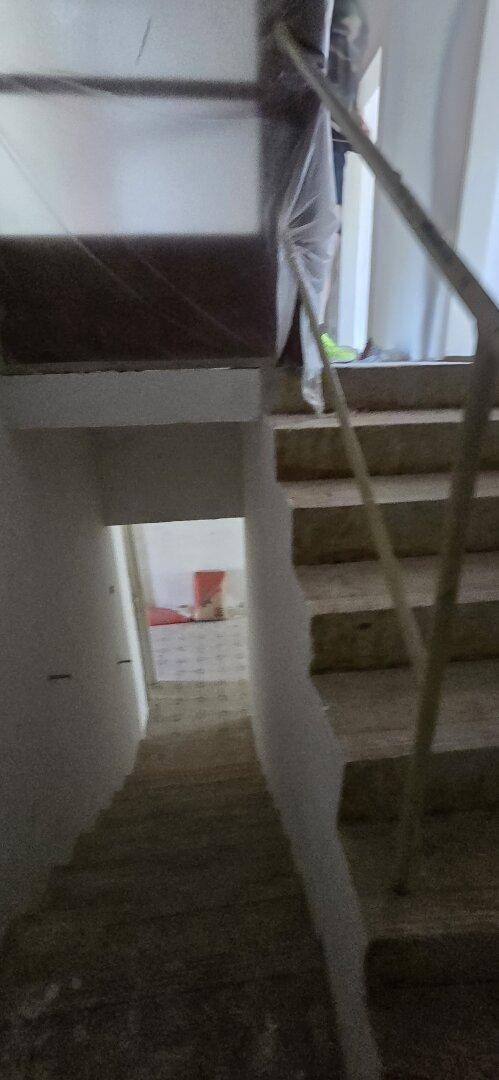 Unscharfes Bild eines Treppenhauses, das sich in einem renovierungsbedürftigen Zustand befindet.