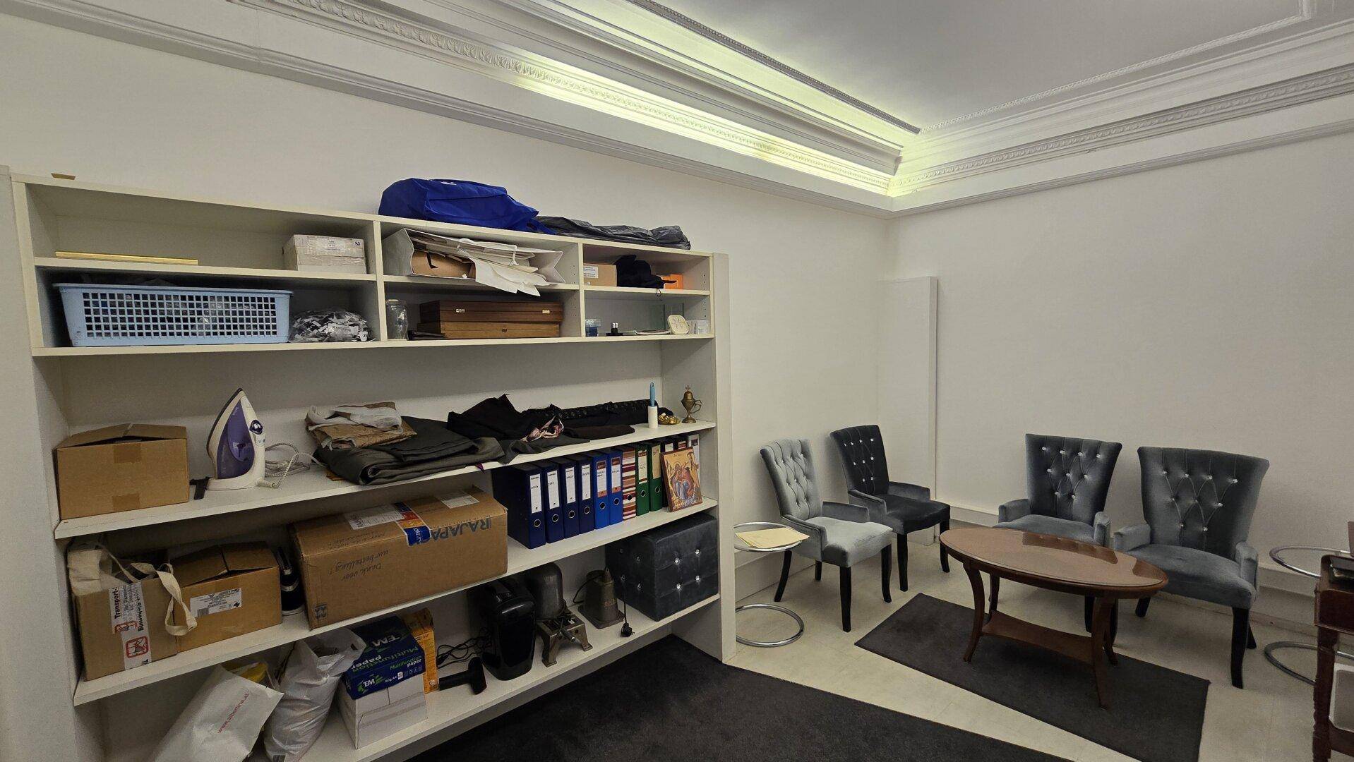 Organisiertes Lager mit Regalen voller Gegenstände und einer kleinen Sitzecke.